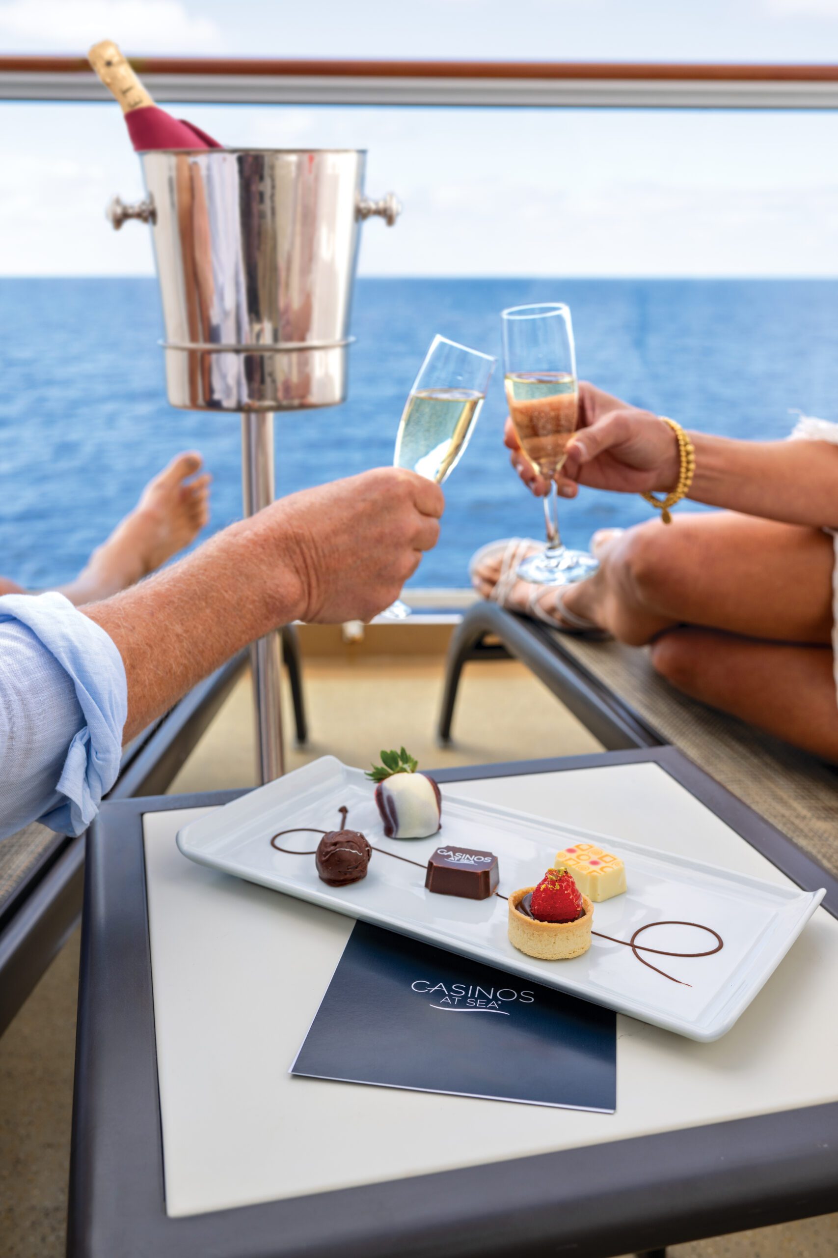 Couple raising champagne glasses in toast, ocean breeze celebration