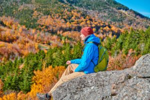 Backpacker man at Artist's Bluff in autumn. Backpacker man hiking at Artist's Bluff in autumn. Fall colours in Franconia Notch State Park. White Mountain National Forest, New Hampshire, USA