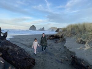 Family walking a beach with sea stacks, Brookings, Oregon