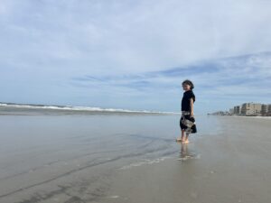 Child walking on a wide flat beach, New Smyrna Beach, Florida