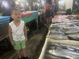 Child at a fish market stall, Bali, Indonesia