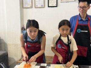 Kids at a Thai cooking class with the instructor, Chiang Mai, Th