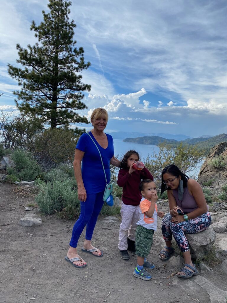 A family standing on a rocky ridge among pines with Lake Tahoe below