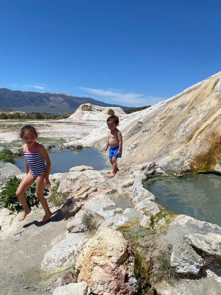 Kids walking on white travertine terraces and pools near Bridgeport