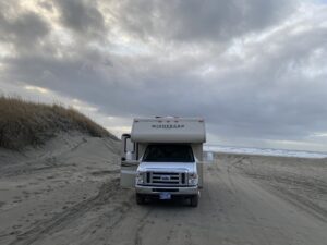 Class C motorhome parked on a wide sandy beach at Sunset Beach near Warrenton, Oregon